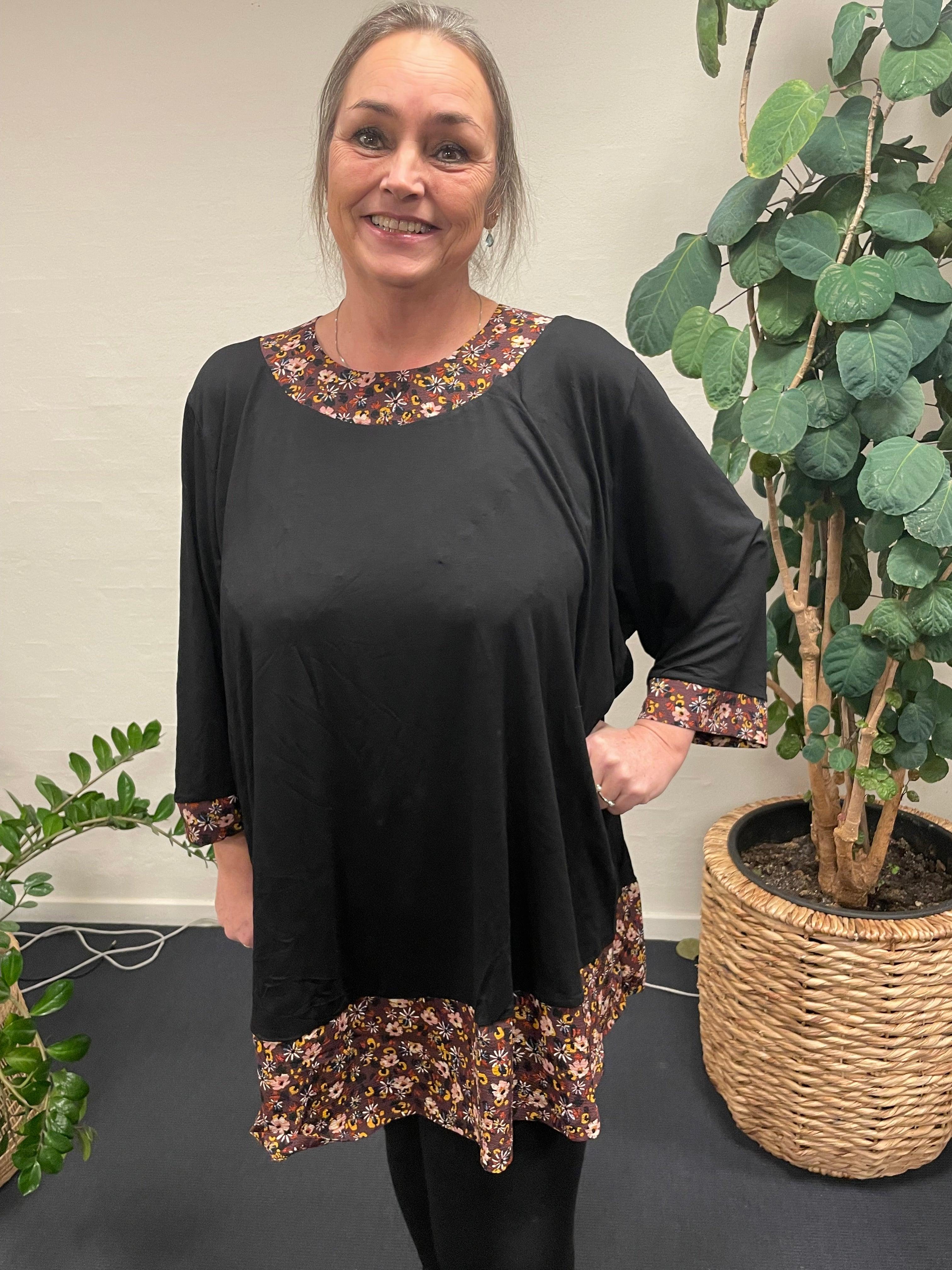 Pronto woman - LisG A-tunika med blomster, bæres af smilende kvinde.