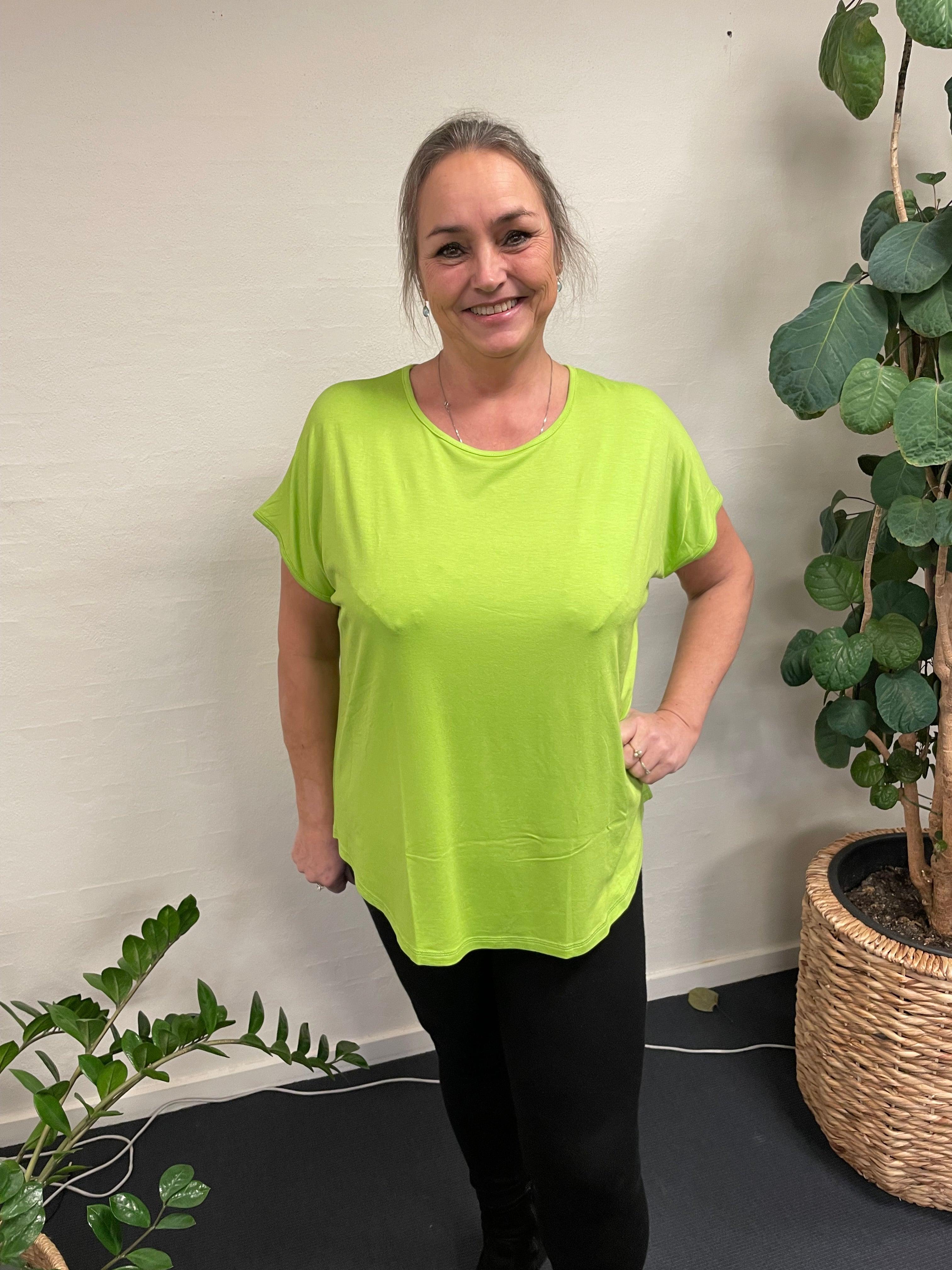 Kvinde iført Gizzip Basic T-Shirt-47 foran en plante.