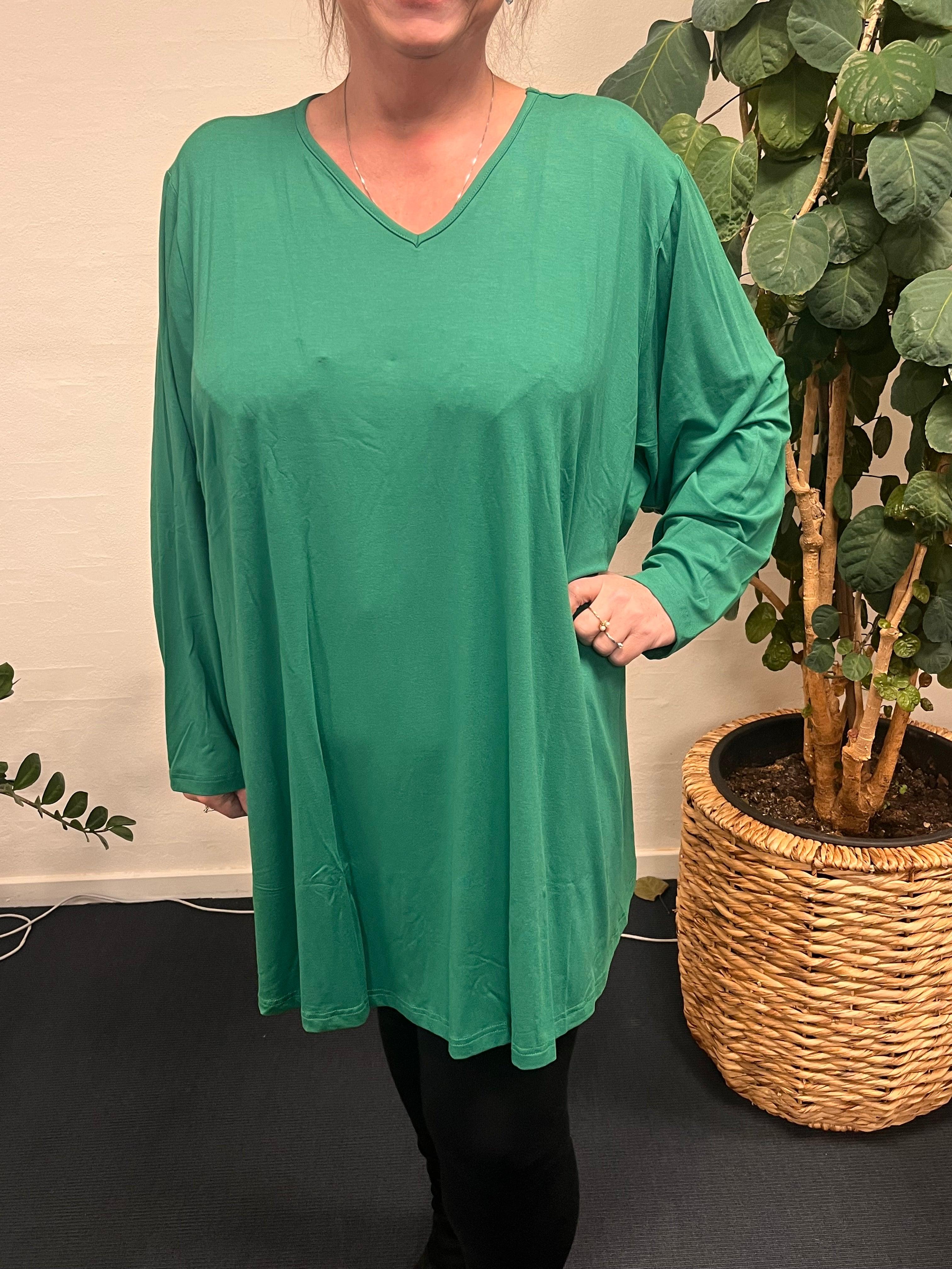 Pronto Woman- LisG tunika i A-facon, båret af kvinde foran plante.