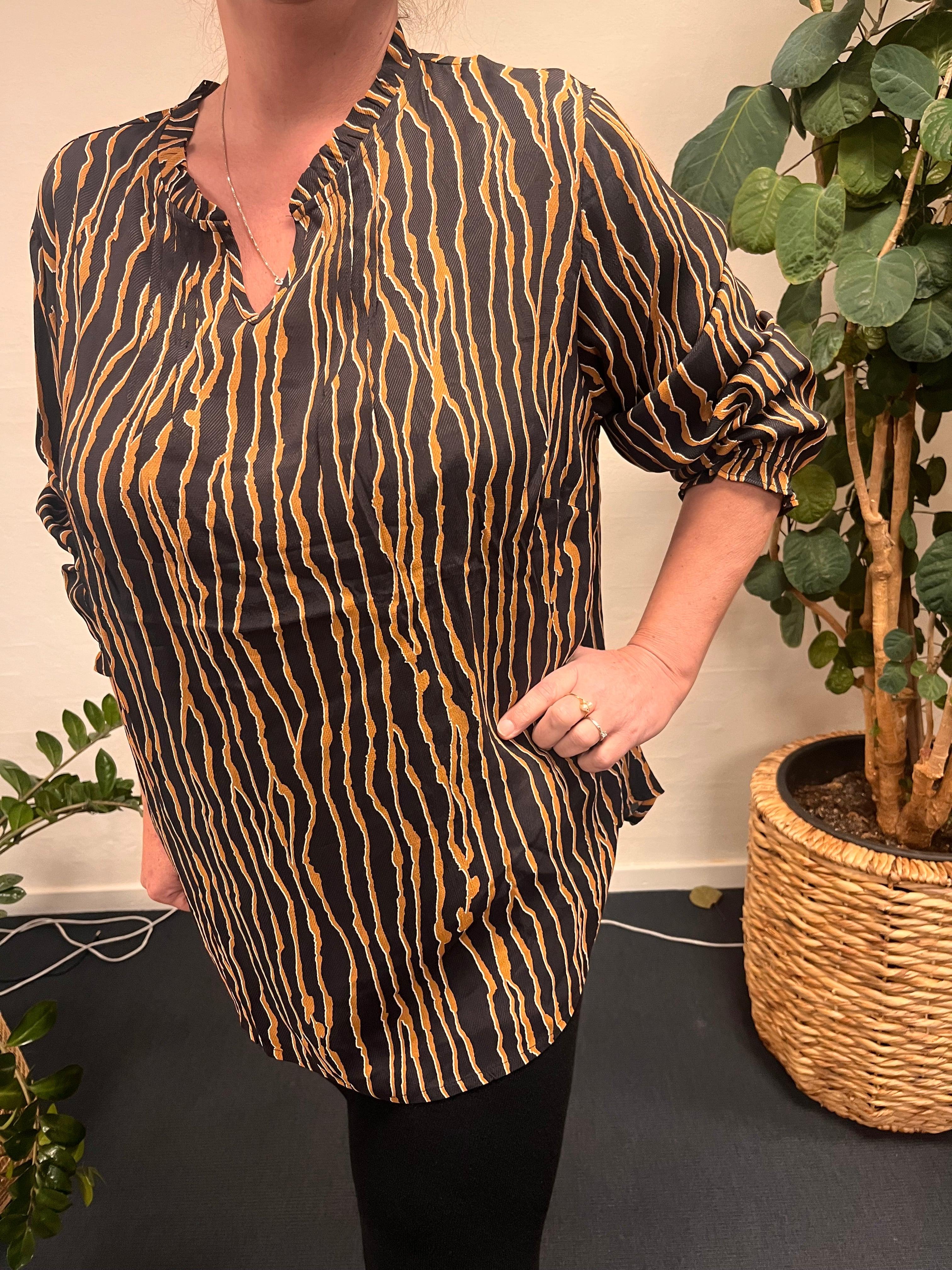 Kvinde iført Ciso bluse m. Print med unik mønsterdetalje.