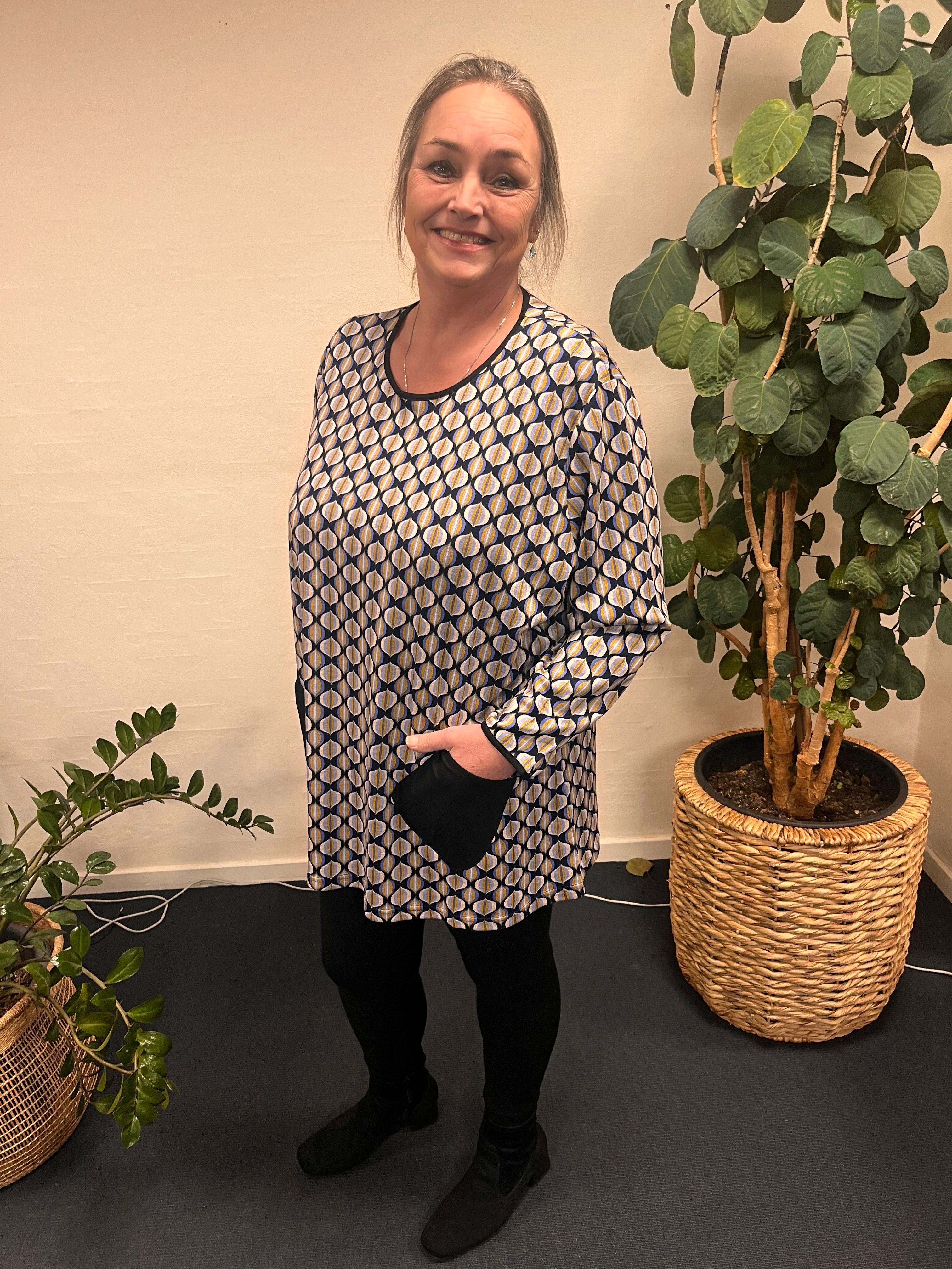 Kvinde i Pronto Woman - LisG bluse med lommer, foran planter.