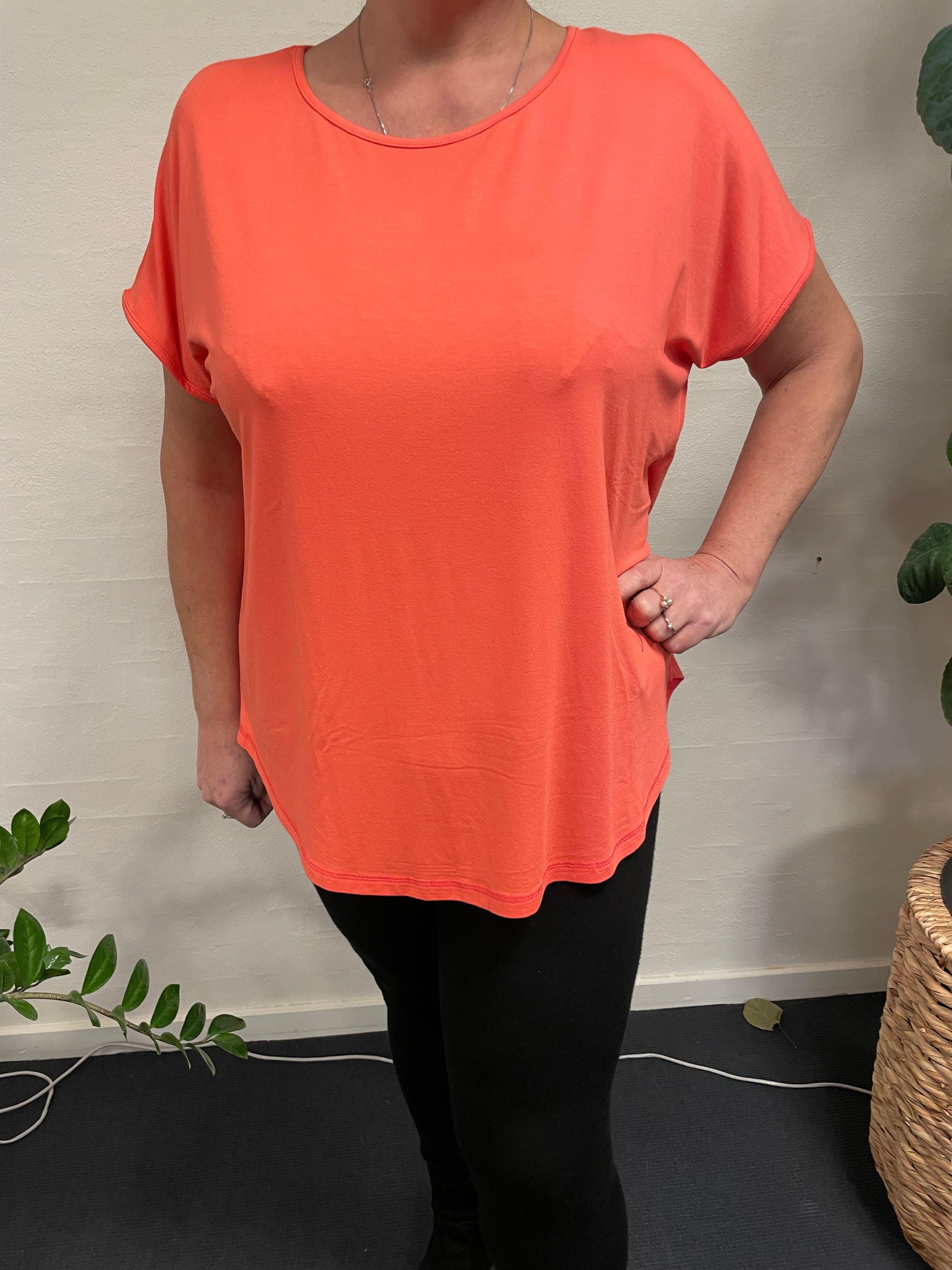 Kvinde iført Gizzip Basic T-Shirt-47 foran en plante.