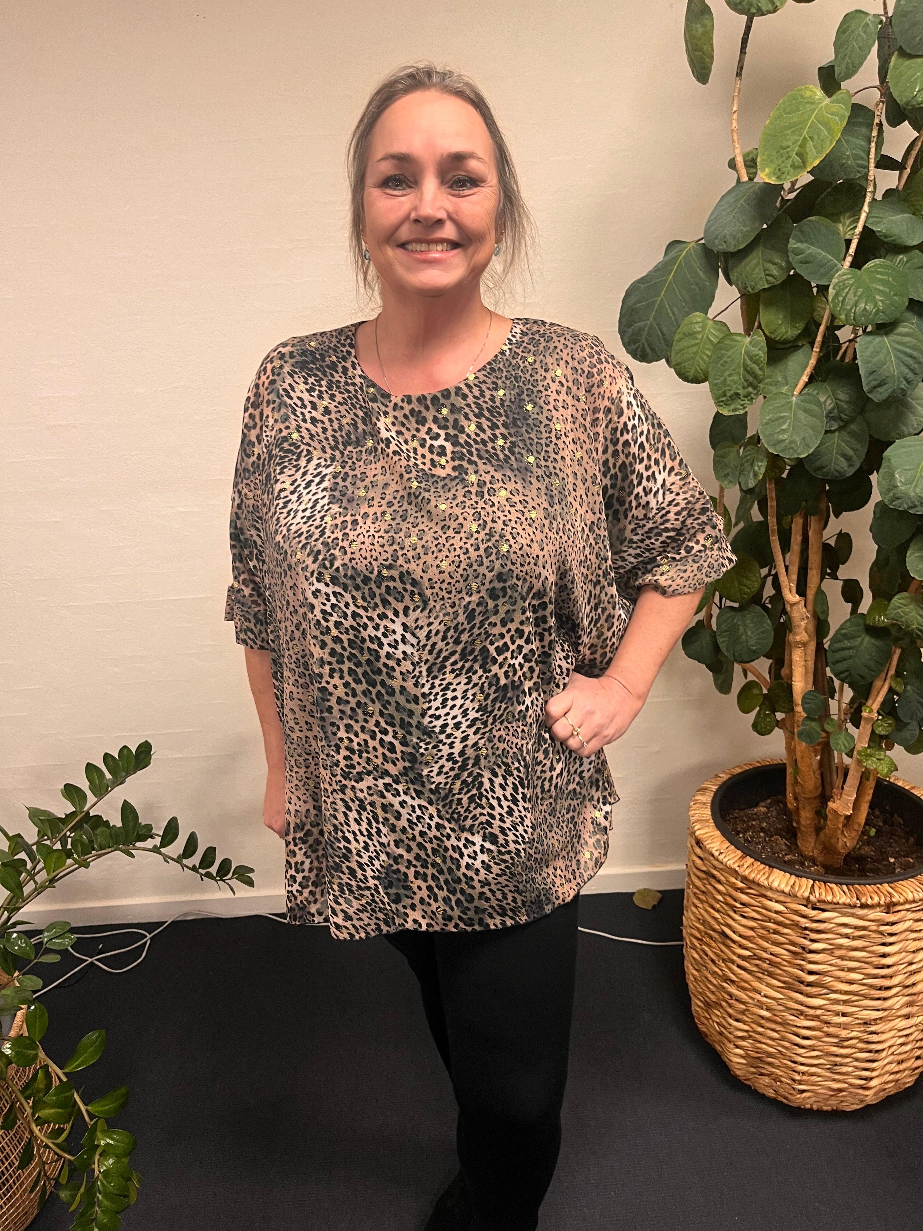 Kvinde i Pronto Woman Lis G Leo tee foran plante.