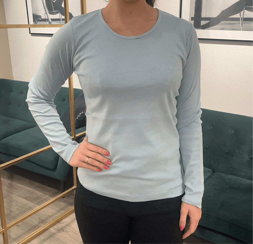 InTownFashion | bluse i frost-blå set på kvinde foran spejl.