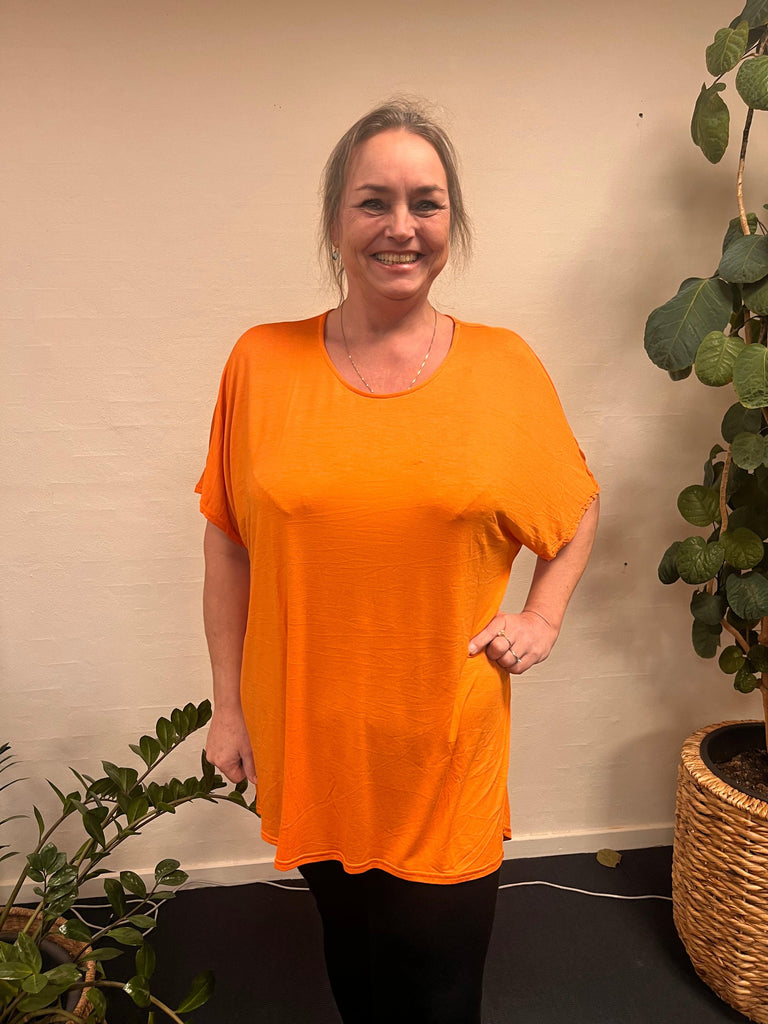 Kvinde i LisG | T-Shirt orange-46, holder plante.