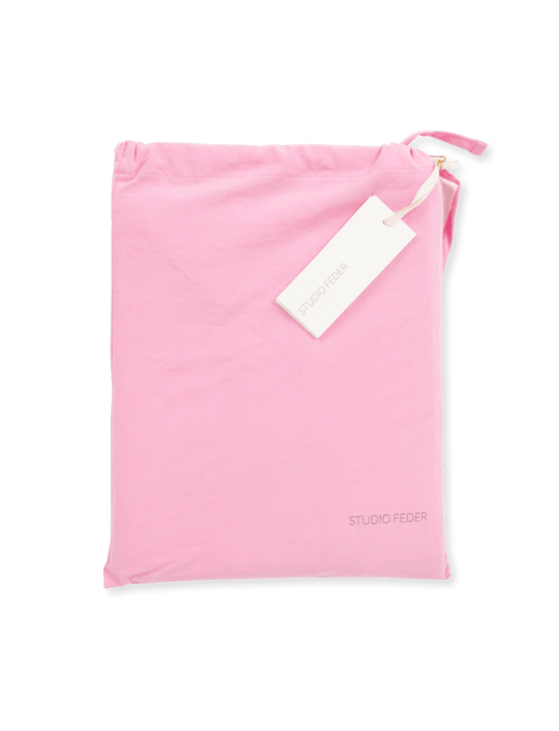 Studio feder | børnesengetøj 70x100 med tag på pink stof.